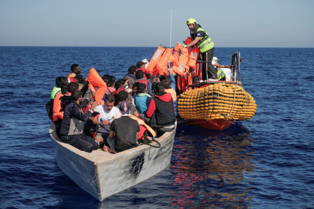 Crew members of NGO rescue ship 'Ocean Viking' give lifejackets to migrants in the Mediterranean Sea